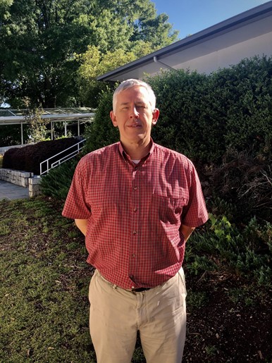 New teacher Mike Butler poses outside his classroom.