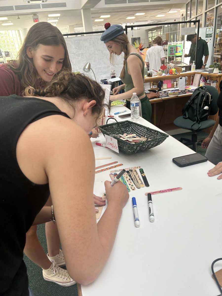 Students Annie Luke and Nina Kline are customizing their popsicle sticks.